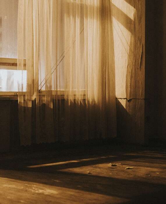 Empty old room with sheer curtains
