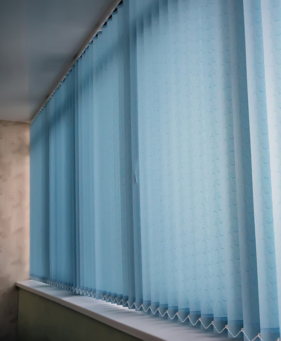 Blue vertical blinds on the long window on the balcony. Modern interior design. Closed window from sunlight